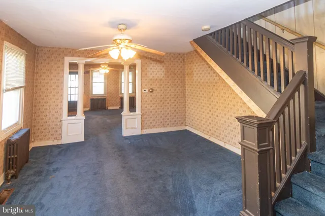 a view of a livingroom with wooden floor and staircase
