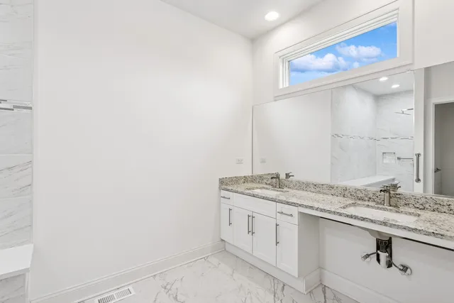 a bathroom with a granite countertop sink and a mirror