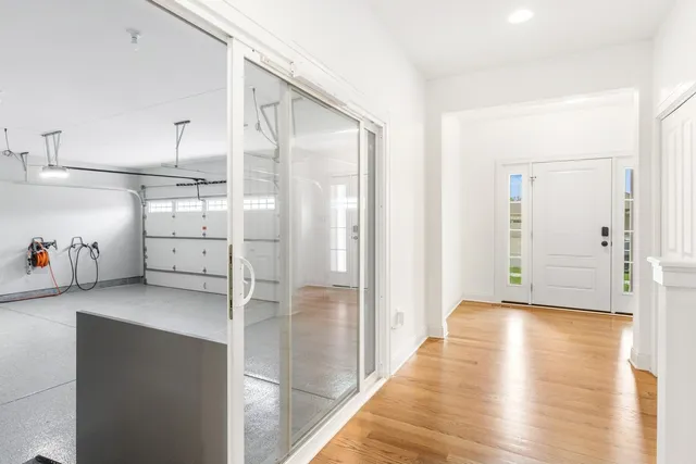a hallway with white cabinets and wooden floor