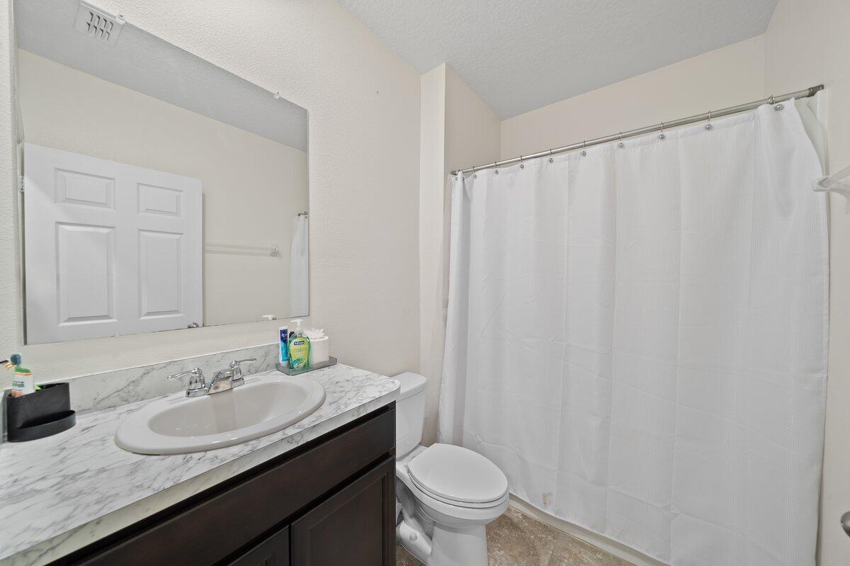 1652 Saxton Road Cocoa, FL 32926 - Photo 13 of 30 a bathroom with a granite countertop sink and a mirror with toilet