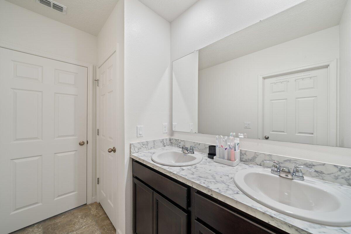 1652 Saxton Road Cocoa, FL 32926 - Photo 25 of 30 a bathroom with a granite countertop sink and a mirror