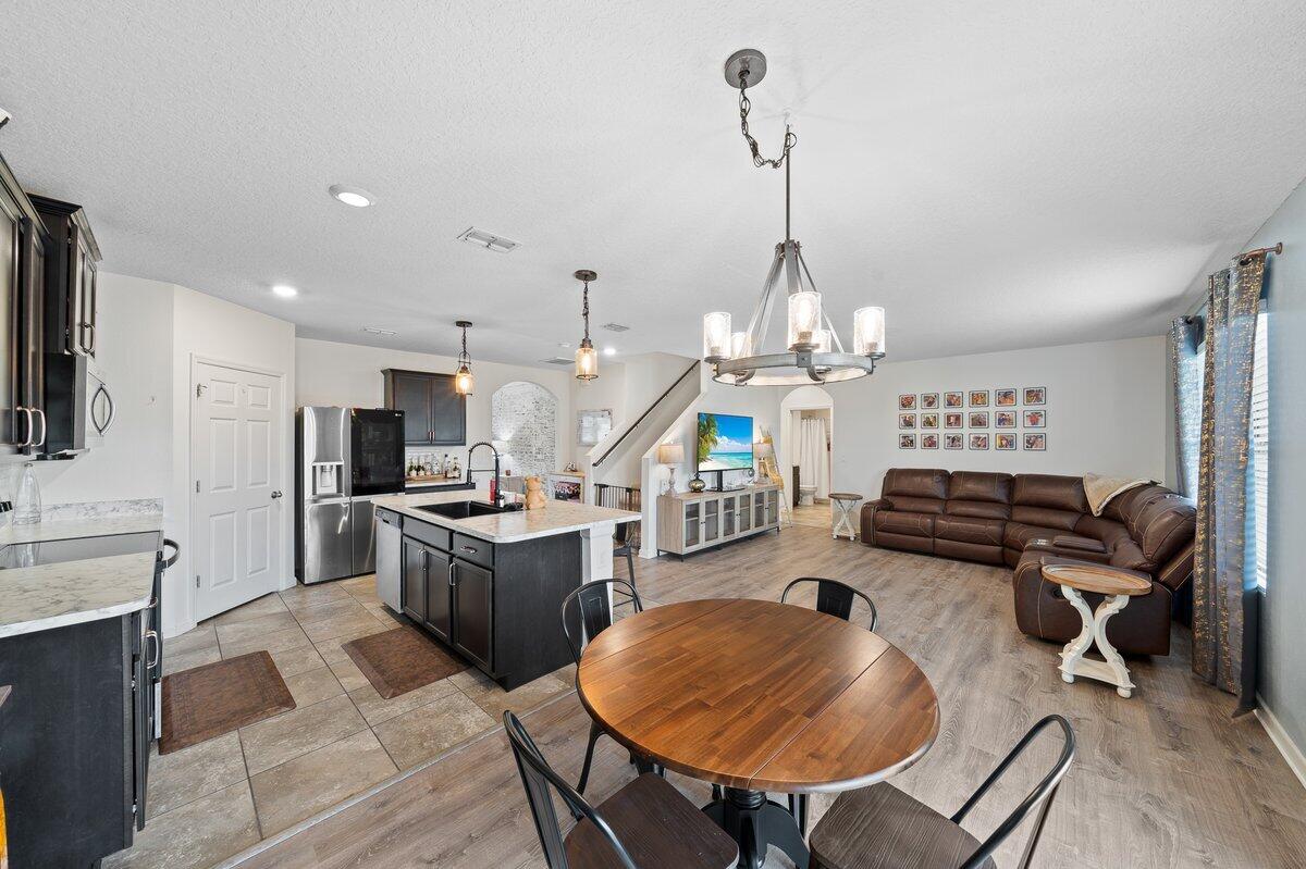 1652 Saxton Road Cocoa, FL 32926 - Photo 8 of 30 a kitchen with sink a stove and chairs