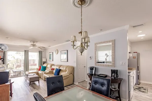 a living room with furniture a flat screen tv and a chandelier