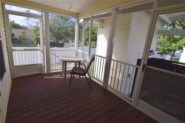 a view of a porch with wooden floor and outdoor seating