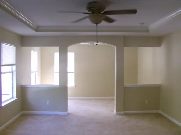 an empty room with windows & fan