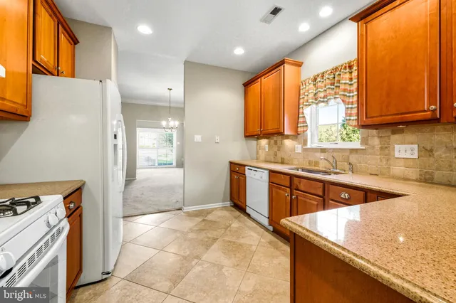a kitchen with stainless steel appliances granite countertop a sink a stove and a refrigerator