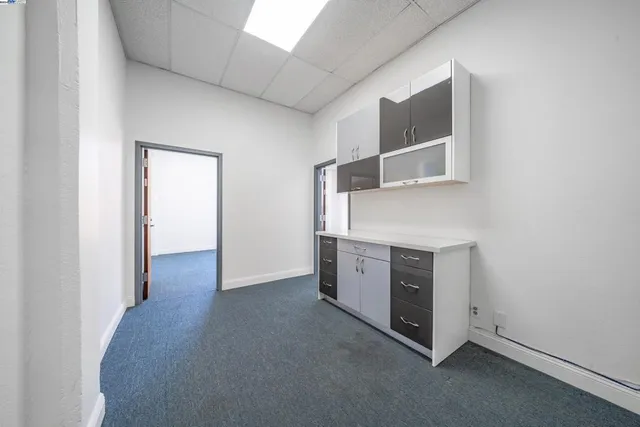 a view of an empty room with cabinet and entryway