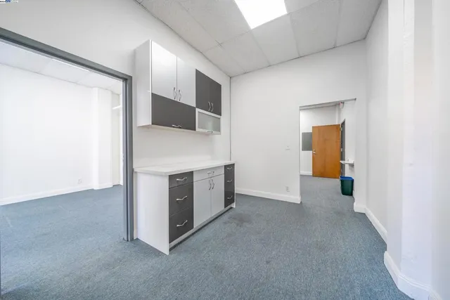 a view of a kitchen with furniture and an empty room