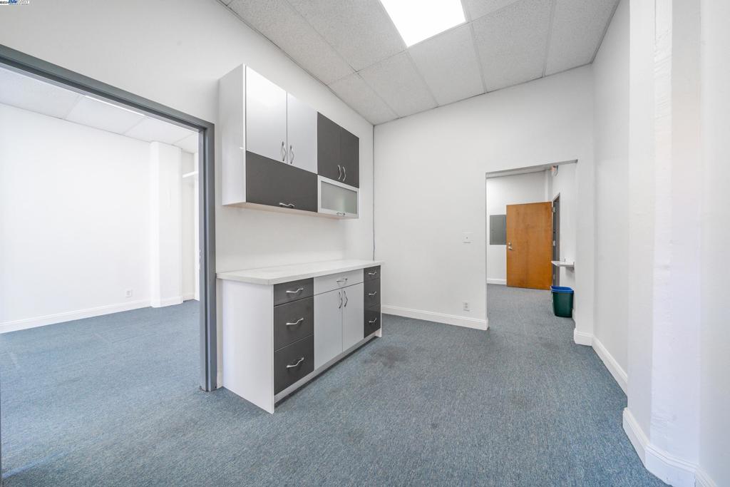 212 9th Street, Unit 208 Oakland, CA 94607 - Photo 6 of 13 a view of a kitchen with furniture and an empty room