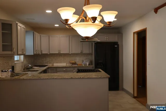 a kitchen with stainless steel appliances granite countertop a sink a stove and a refrigerator