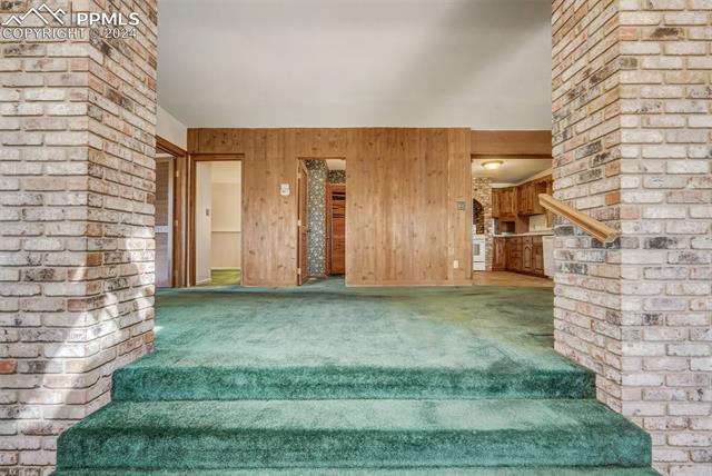 23555 Murphy Road Calhan, CO 80808 - Photo 26 of 49 Staircase featuring wooden walls and carpet flooring