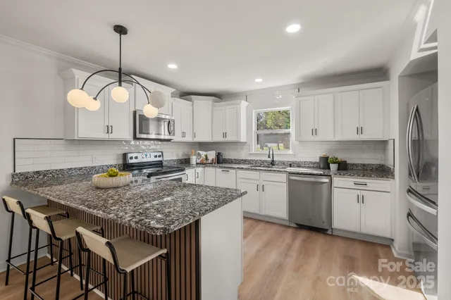 a kitchen with kitchen island granite countertop a sink a center island and cabinets