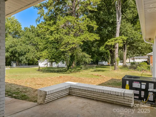 a view of swimming pool with lawn chairs and plants