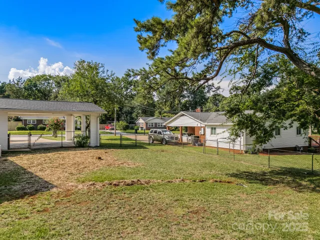 a white house covered with tall trees