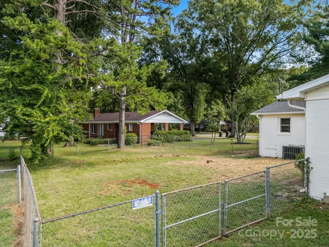 a view of a house with backyard and trees