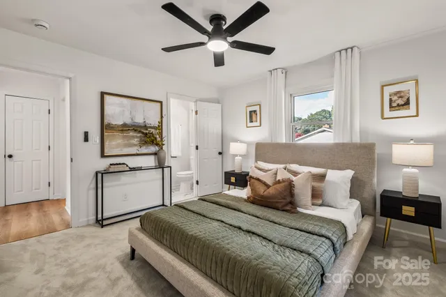 a bedroom with a large bed and a chandelier
