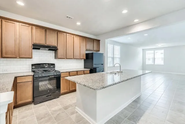 a kitchen with stainless steel appliances granite countertop a sink stove and cabinets