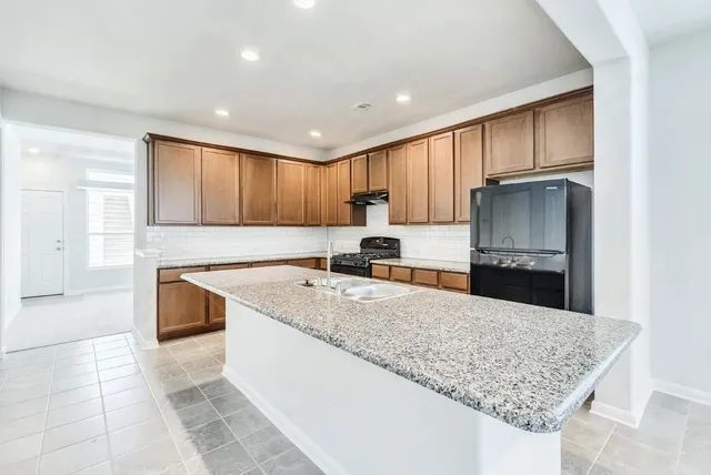 a kitchen with stainless steel appliances granite countertop a sink stove and refrigerator