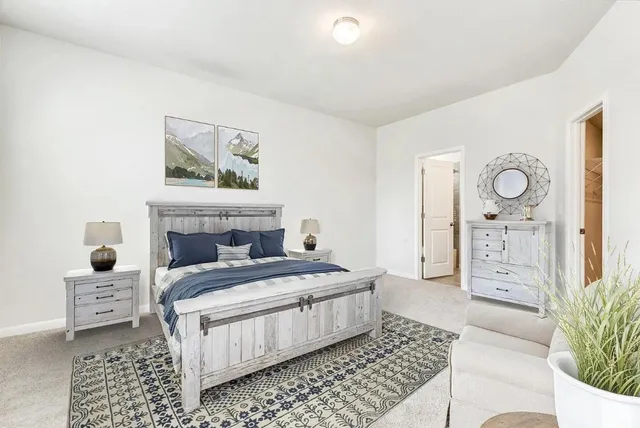 a bedroom with a bed a mirror and lamp