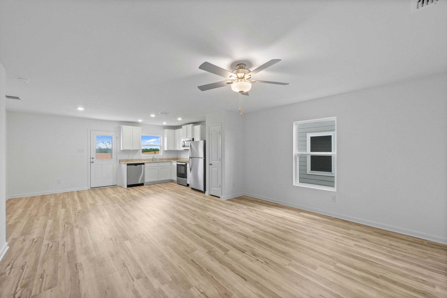 401 Silent Meadow Run Maxwell, TX 78656 - Photo 3 of 11 Unfurnished living room with light wood-style floors, recessed lighting, and ceiling fan