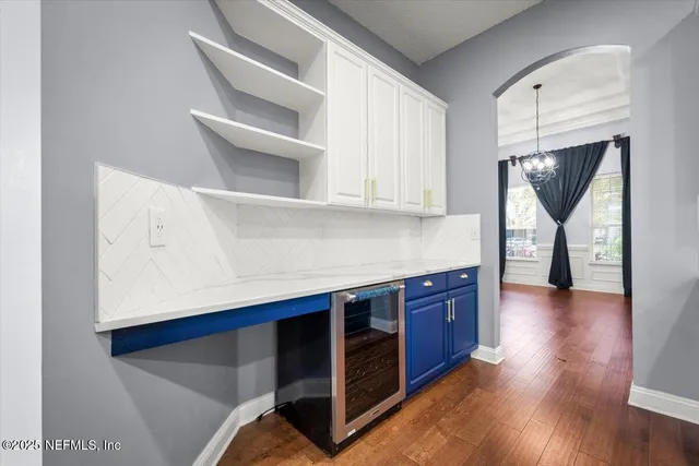 a kitchen with stainless steel appliances cabinets and wooden floor