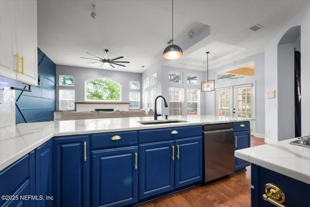 a kitchen with stainless steel appliances wooden cabinets a center island and windows