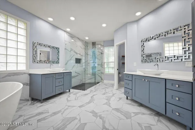 a spacious bathroom with a double vanity sink a mirror and a bathtub