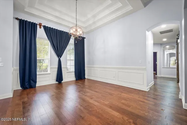 a view of a livingroom with wooden floor staircase and a kitchen space