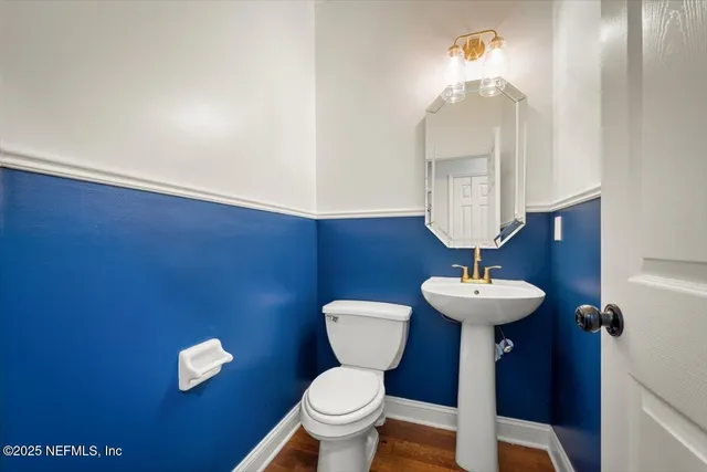 a bathroom with a toilet sink and mirror