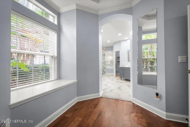 a view of a hallway with wooden floor and a living room