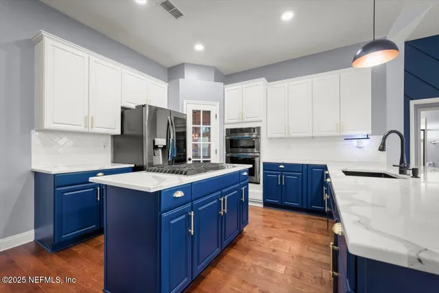 a kitchen with stainless steel appliances granite countertop a stove a refrigerator and a sink