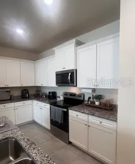 a kitchen with a sink a stove and cabinets