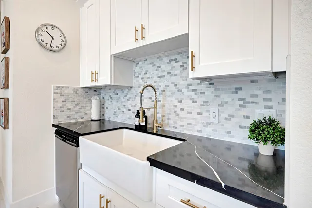 a kitchen with granite countertop a sink and a stove