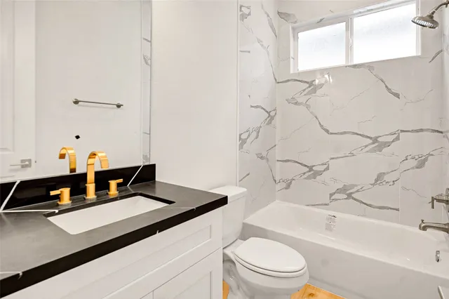 a bathroom with a sink a toilet and bathtub