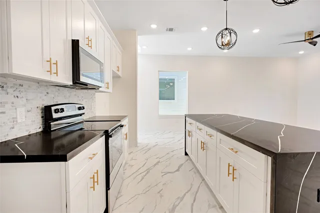 a kitchen with granite countertop a stove and a sink