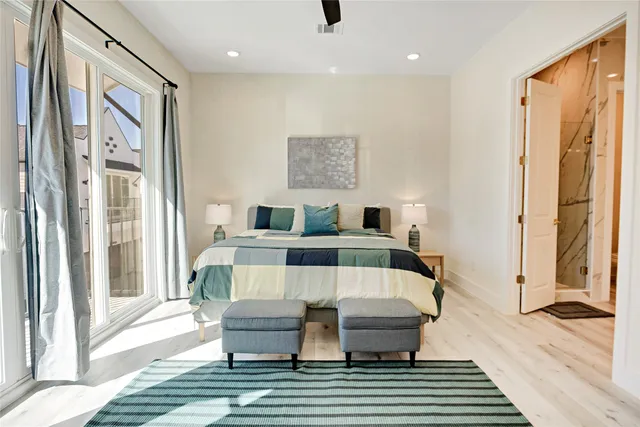 a bedroom with a bed lamp and a large window