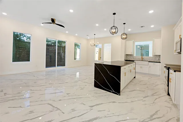 a large white kitchen with a large window