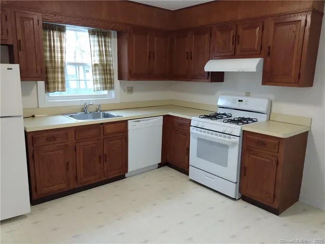 a kitchen with a stove sink and cabinets