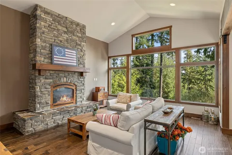 a living room with furniture a fireplace and a large window