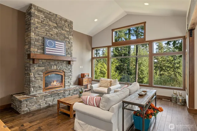 a living room with furniture a fireplace and a large window
