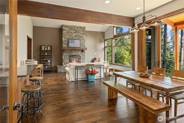 a living room with furniture a large window and wooden floor