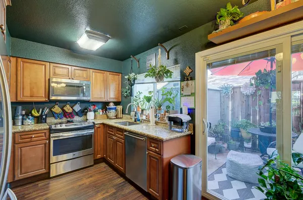 a kitchen with stainless steel appliances granite countertop a stove a sink and a refrigerator