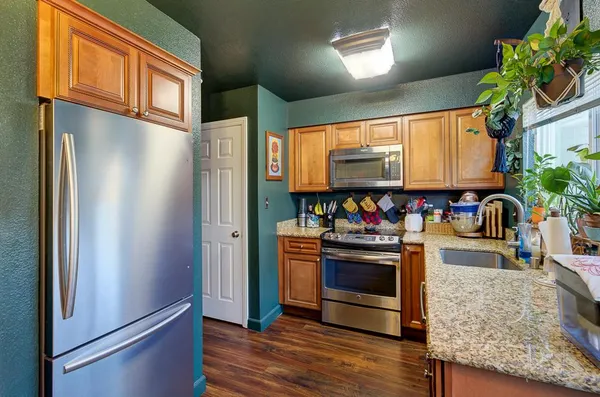 a kitchen with stainless steel appliances granite countertop a refrigerator and a sink