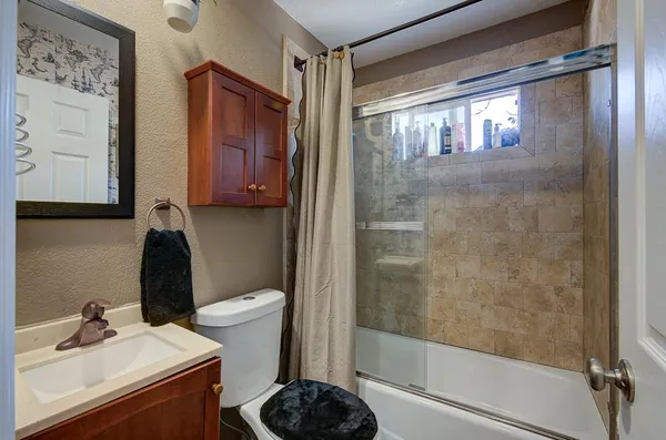 a bathroom with a sink a toilet and shower