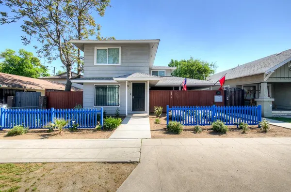 a view of a house with a yard and a large tree