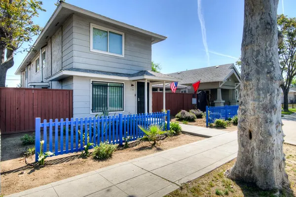 a view of a house with a small yard and wooden fence