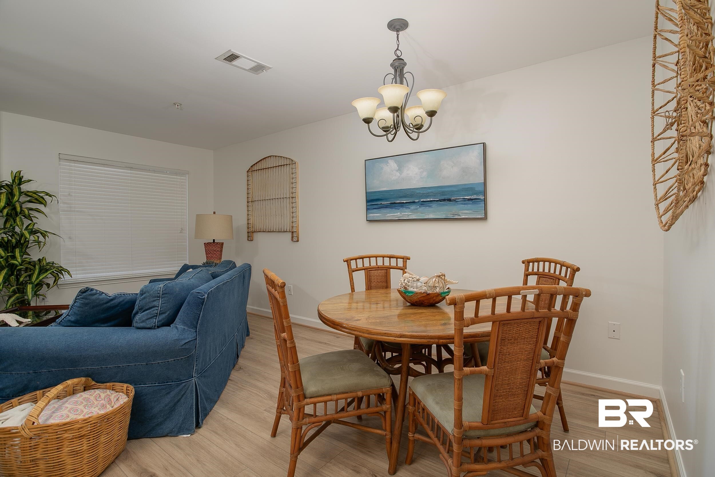 1517 Regency Road, Unit 33 Gulf Shores, AL 36542 - Photo 7 of 29 Dining space featuring light wood-type flooring, baseboards, a notable chandelier, and visible vents