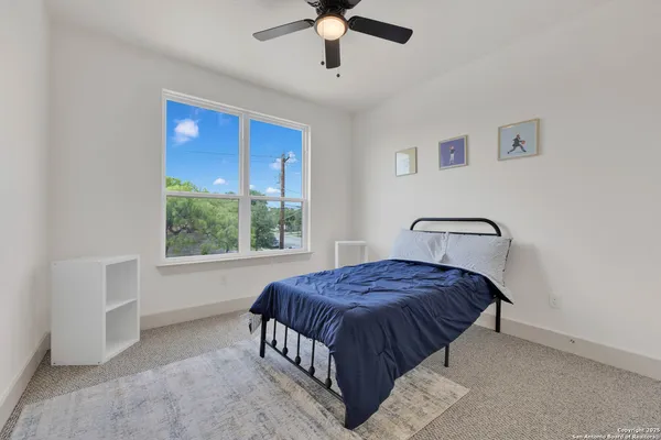 a bedroom with a large bed and a chandelier