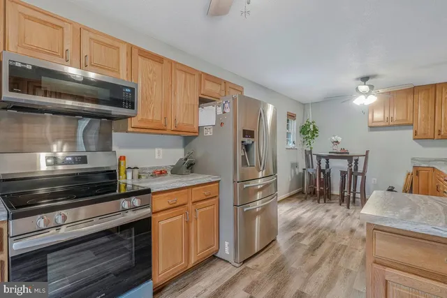 a kitchen with granite countertop a refrigerator stove top oven and sink