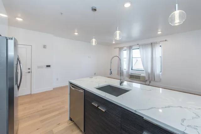 a kitchen with a sink a refrigerator and cabinets